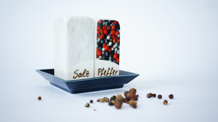 Ceramic pepperbox and salt cellar with pepper corns isolated on whiteの写真素材