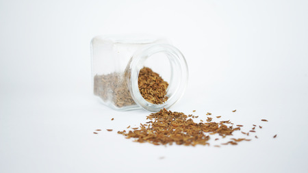 Glass jar with cumin isolated on whiteの写真素材
