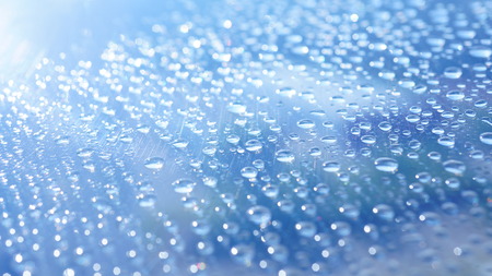 Water bubbles on the glass with blue skyの写真素材