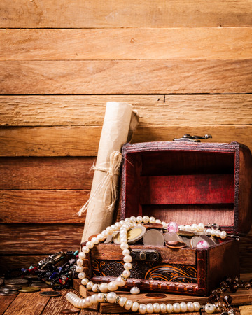 Open wooden treasure chest with valuables on wooden backgroundの写真素材