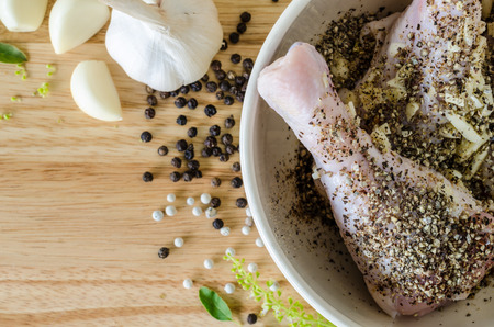 Raw chicken legs  preserved with  spices in a bowl,prepare for cooking.の写真素材