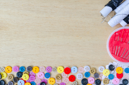 Colorful buttons, Clasper and sewing kit close up on wooden background.の写真素材