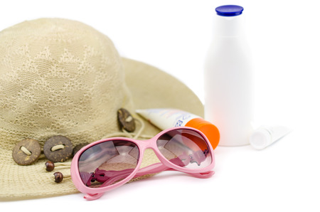 Beach hat with sunglasses and sunscreen isolated on white background