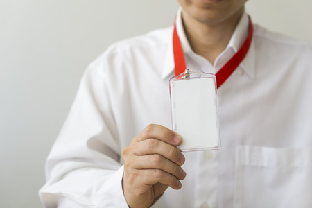 Man holding Identification white blank plastic id card.の写真素材