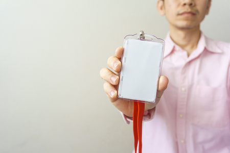 Man holding Identification white blank plastic id card.の写真素材