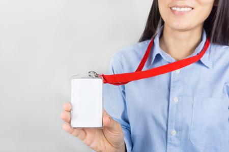 Woman holding Identification white blank plastic id card.