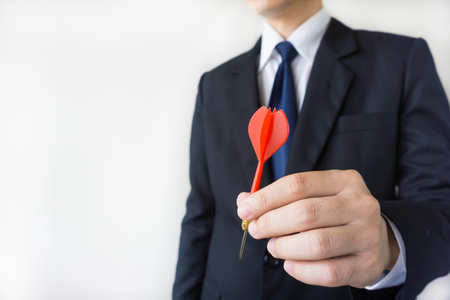 Businessman holding a dart  - business targeting, aiming, focus concept.の写真素材