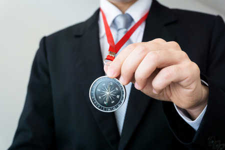 Businessman holding a compass  - business targeting, aiming, direction, focus concept.の写真素材
