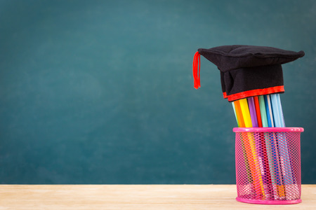 Pencils and graduation hat Concept of education or back to school on green backgroundの写真素材