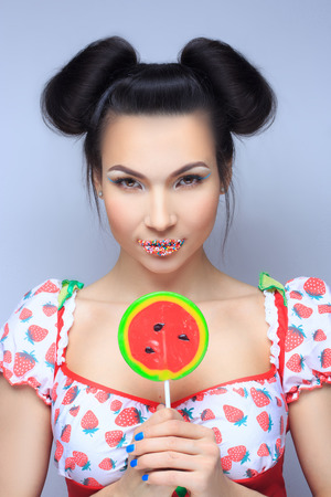 Beautiful pin-up girl holding sweet lollipopの写真素材