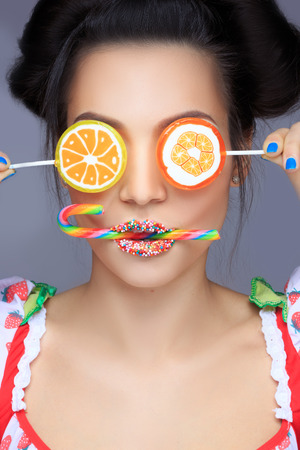 Beautiful pin-up girl holding sweet lollipopの写真素材