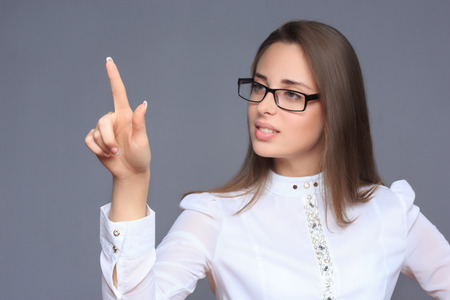 woman pointing her finger on imaginery buttonの写真素材