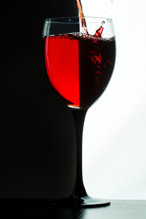 Red wine pouring. white on black backgroundの写真素材
