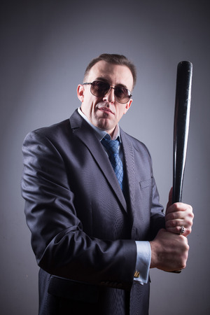 male gangster with glasses and a baseball batの写真素材