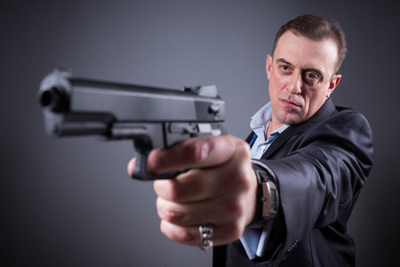 man in a business suit with a gun