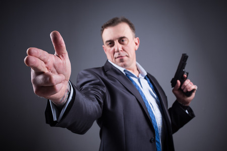 man in a business suit with a gunの写真素材