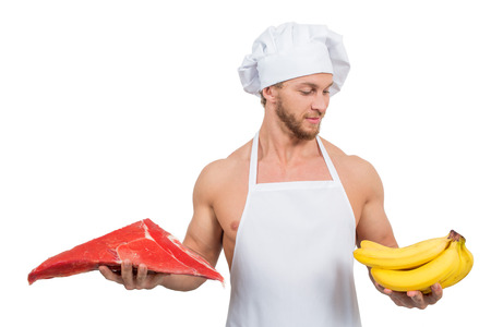 chef in a white apron holding meat and bananasの写真素材