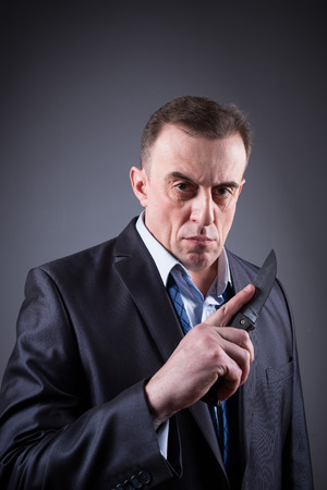 male gangster in a business suit with a knifeの写真素材