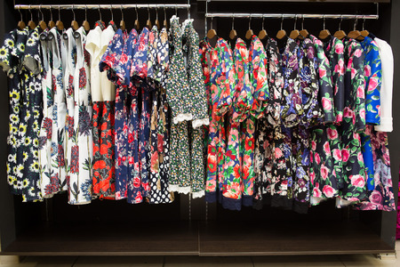 womens dresses on hangers in a retail shopの写真素材