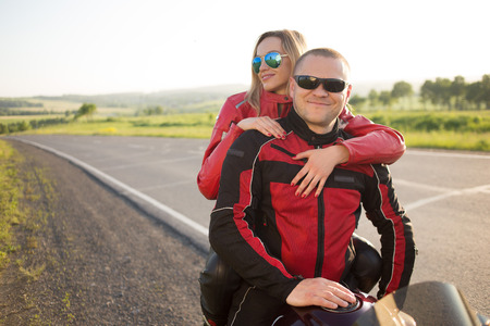 biker man and woman sitting on a motorcycle.の写真素材