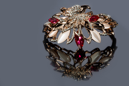 golden bracelet with precious stones on grey backgroundの写真素材