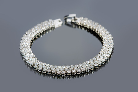 golden bracelet with precious stones on grey backgroundの写真素材