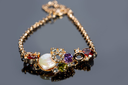 golden bracelet with precious stones on grey backgroundの写真素材