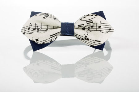 white bow tie with notes on a white backgroundの写真素材