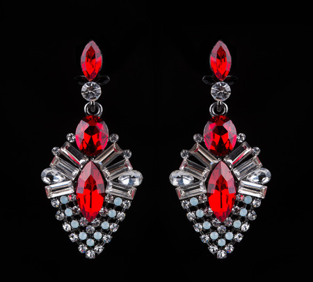 Beautiful earring with colorful red gems on black backgroundの写真素材