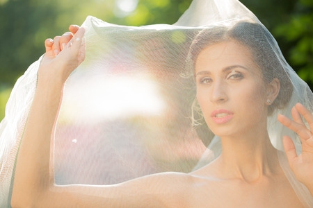wedding bride smiling. woman in a wedding dress in the park. blurred backgroundの写真素材