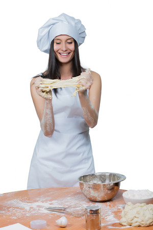 sexy  woman in chef uniform knead the dough on white backgroundの写真素材