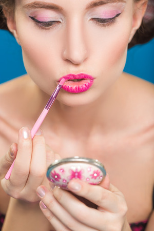 Sexy young pin-up girl doing make-up. lipstickの写真素材