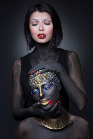 Two girl witch in black paint with gold ornaments. murderの写真素材