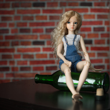 beautiful doll with a bottle. the concept of alcoholismの写真素材