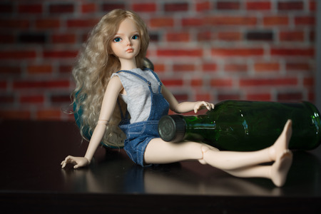 Beautiful doll on a background of a brick wall.の写真素材