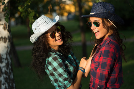 Two sexy young women in cowboy hats and plaid shirts. sunglassesの写真素材