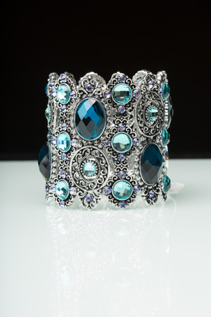 Bracelet with blue stones over black  background.の写真素材