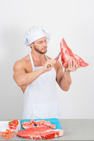 bodybuilder man holding a piece of raw meat. on a white backgroundの写真素材