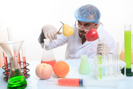 scientist fills chemicals fruit and vegetables. chemistryの写真素材