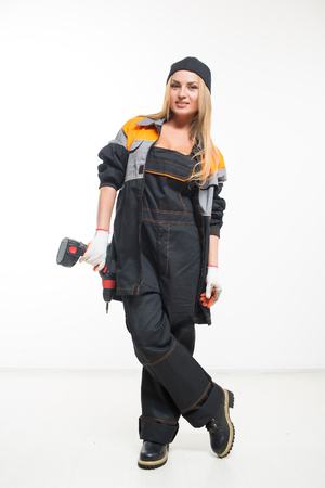Young sexy female holding a cordless screwdriver. white isolated backgroundの写真素材