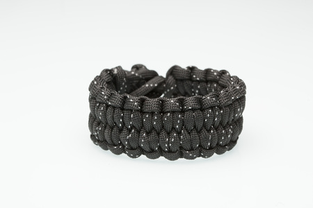Black braided bracelet on white background.  synthetic cordの写真素材