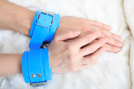 Male and female hands in handcuffs. couple in bed. sex Toysの写真素材