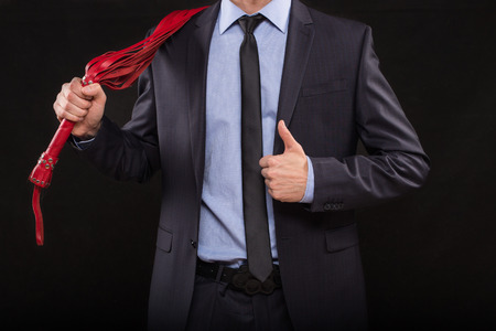 a man in a business suit with chained hands. handcuffs for sex gamesの写真素材