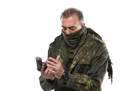 Male terrorist in a military jacket with a gun in his hand. isolated on white background.の写真素材
