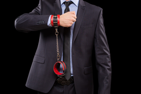 a man in a business suit with leather bound with handcuffs. sex Toys