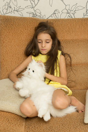 Sad little girl hugging her toy. houseの写真素材