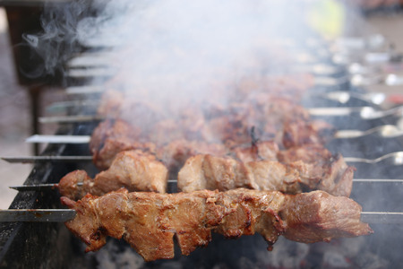 Grilling marinated shashlik on a grill. Shashlik is a form of Shish kebabの写真素材
