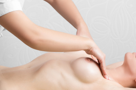 Beauty young woman recieving breast massage at spa.の写真素材
