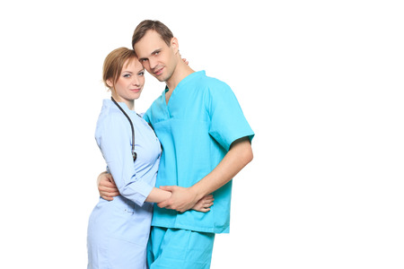 A male and a female doctor kissing at work.の写真素材