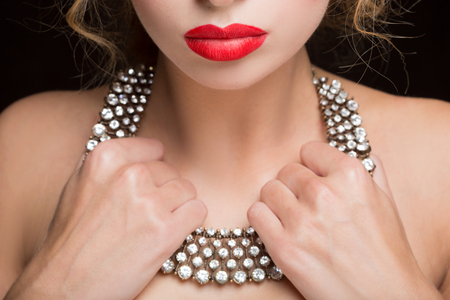 necklace on female neck. girl holding hands. sexy red lips.の写真素材
